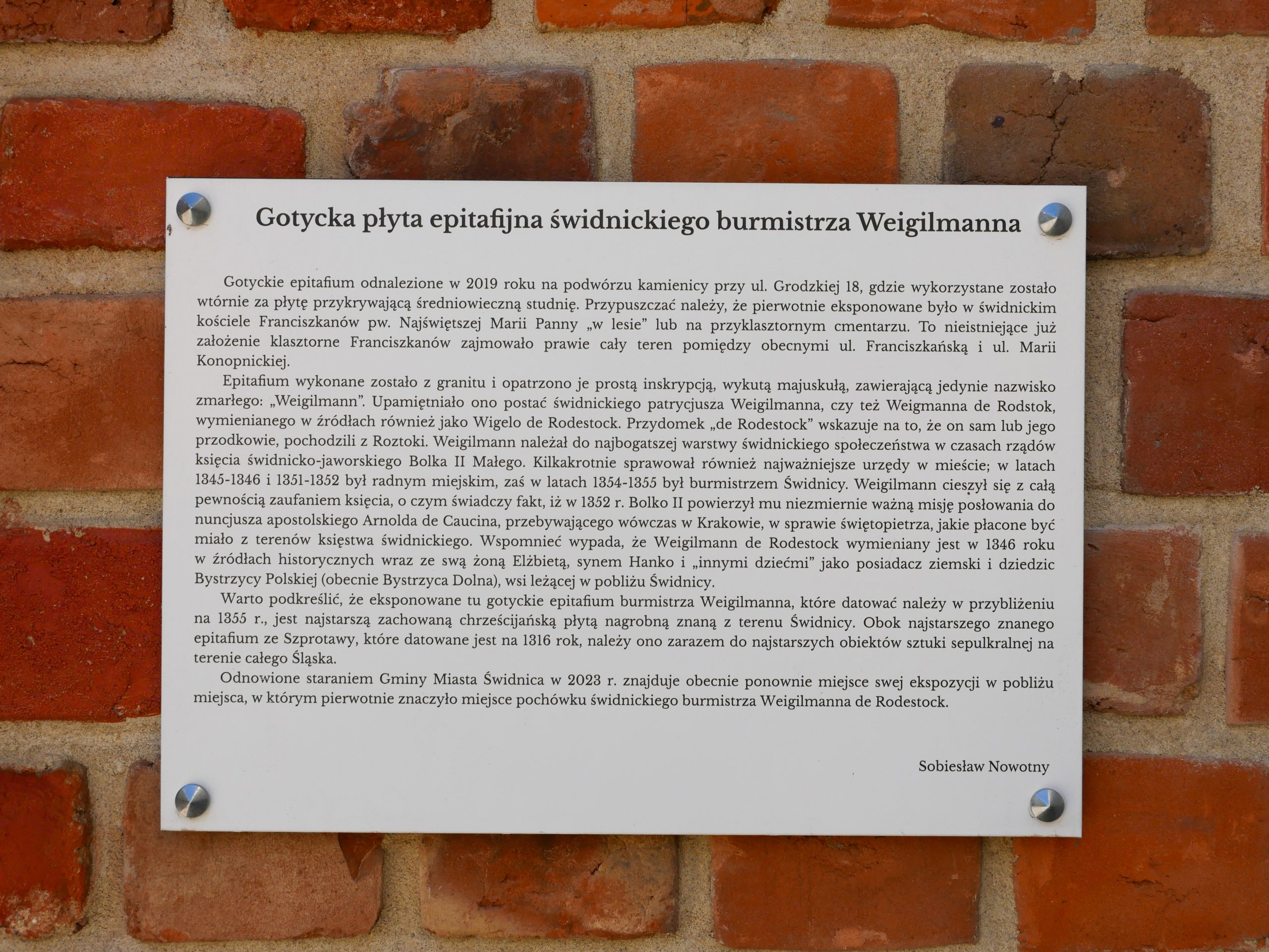 Zdjęcie tablicy opisującej historię plyty gotyckiej świdnickiego burmistrza Weigilmanna.